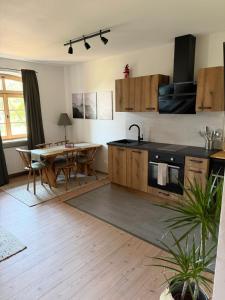 a kitchen with a table and a sink and a kitchen with a dining room at falternhof apartment - geschichte trifft auf design in Höslwang