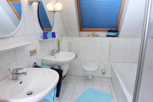 ein weißes Badezimmer mit Waschbecken und Toilette in der Unterkunft Ferienhof Lafrenz in Cuxhaven + 14 Fotos
