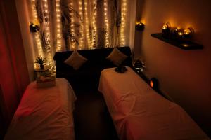 two beds in a room with lights on the window at BLOM Spa privatif près de Douai, salle de massage, petit-déjeuner inclus in Guesnain