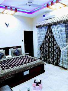 a bedroom with a bed and curtains in a room at Hotel Moon Light view in Lahore