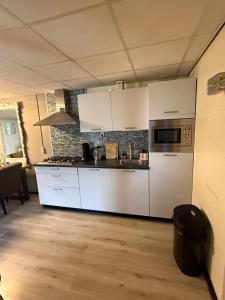 a kitchen with white appliances in a room at The Quiet Escape in Strijen