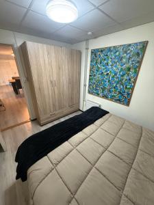 a bedroom with a large bed and a painting on the wall at The Quiet Escape in Strijen