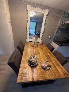 a wooden table with a mirror and some food on it at The Quiet Escape in Strijen +8 photos