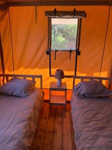 a bedroom with two beds and a window at Gîte les 7 saveurs in Cucugnan