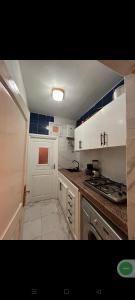 a small kitchen with white cabinets and a stove at Appart Dakhla Cool in Dakhla