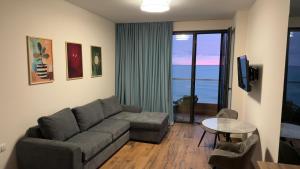 a living room with a couch and a table at Go Bamboo Beach Apartments in Ts'ikhisdziri