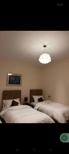 a bedroom with two beds and a light hanging from the ceiling at Appart Dakhla Cool in Dakhla