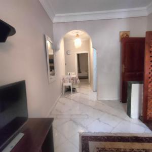 a living room with a table and a hallway at Appart Dakhla Cool in Dakhla