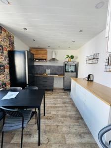 a kitchen with a black table and chairs and a counter at CityStay House 42 in Bremerhaven