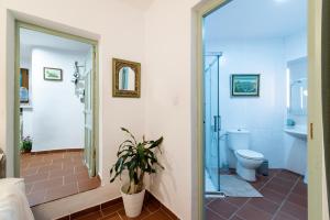 a bathroom with a toilet and a glass shower at Patio Morisco - WIFI - free parking in Órgiva