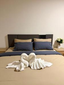 a bed with two white towels on it at Breezy 1BR Near BTS Udomsuk in Amphoe Phra Khanong +19 photos