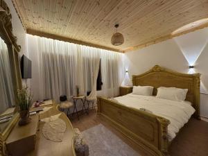a bedroom with a large bed and a desk at Golden Guest House in Gjirokastër