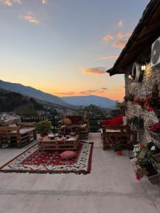 a patio with a table and a view of the mountains at Golden Guest House in Gjirokastër