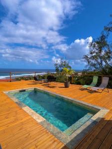 a swimming pool on a deck with a view of the ocean at La Villa Bleu Lagon in Petite Île