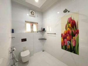 a bathroom with a painting of tulips on the wall at Golden Villas in Rewāri +36 photos