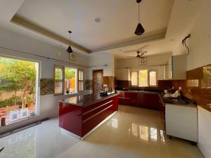 a large kitchen with red cabinets and a large window at Golden Villas in Rewāri