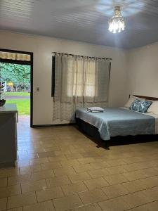 a bedroom with a bed and a large window at Camping e Hostel Internacional in Foz do Iguaçu