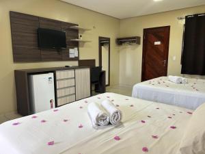 a hotel room with two beds with flowers on them at Pousada Bellissima Italia in Luis Correia +27 photos