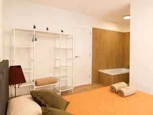 a bedroom with a bed and a tub in a room at CozyCatalonia - Exclusive Attic in Central Blanes in Blanes +18 photos