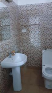 a bathroom with a white sink and a toilet at Esther properties in Entebbe +83 photos