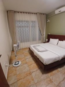 a bedroom with a bed and a window at Esther properties in Entebbe