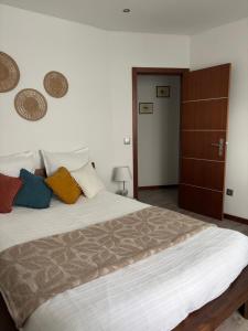 a bedroom with a large bed with colorful pillows at Casinha da Aurora in Pedorido