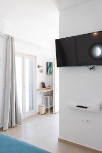 a living room with a flat screen tv on a wall at Orion Sea View Studio in Parasporos