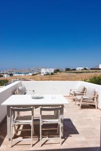 a white table and chairs sitting on a patio at Orion Sea View Studio in Parasporos