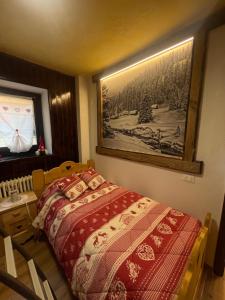 a bedroom with a bed and a picture on the wall at Le Flocon de neige in Valtournenche