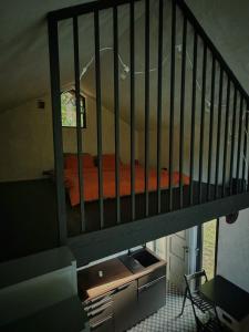 a crib with an orange bed in a room at River Nest Tiny House in Iecava