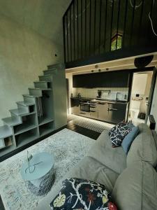 a living room with a couch and a staircase at River Nest Tiny House in Iecava