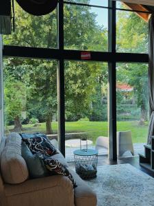 a living room with a couch and a large window at River Nest Tiny House in Iecava
