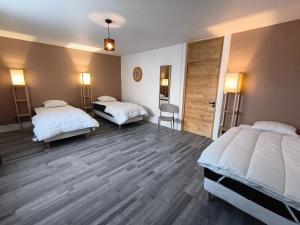 a hotel room with two beds and a closet at NEW! Appartement PrixMalin 1 à 7 personnes in Champagnole