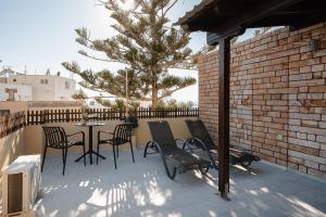 a patio with a table and chairs and a tree at NaxosAir1 in Naxos Chora