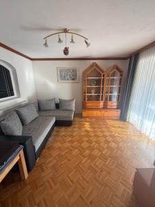 a living room with a couch and a wooden floor at Wohnung im Grünen in Sankt Andrä