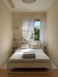 a bedroom with a large bed with a window at Garden Hostel in Aradas