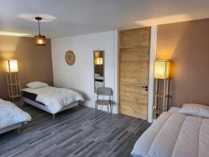 a bedroom with two beds and a sliding door at NEW! Appartement PrixMalin 1 à 7 personnes in Champagnole +10 photos