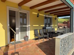 a patio with chairs and a table on a house at Wohnung im Grünen in Sankt Andrä