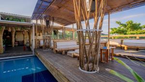 a deck with a pool and chairs and a house at Hotel Pousada Brava Club in Búzios