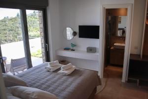 a bedroom with a bed with two towels on it at Villa Thymari in Xiropigado +24 photos