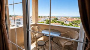 a balcony with a table and chairs in front of a window at Apartmani Enydoo in Ulcinj +18 photos