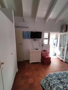 a bedroom with a bed and a tv on the wall at Ocean Walk Starfish in Zinkwazi Beach