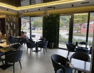 a restaurant with tables and chairs and people sitting at tables at Porto Apartmani in Zvornik