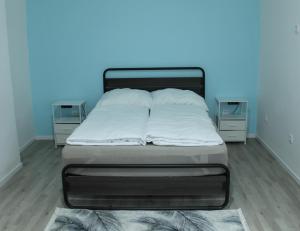 a bed in a room with a blue wall at Royal Racing Suite Top 3 near Red Bull Ring in Judenburg