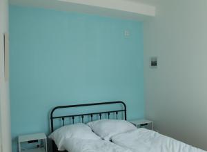 a bed in a room with a blue wall at Royal Racing Suite Top 2 near Red Bull Ring in Judenburg