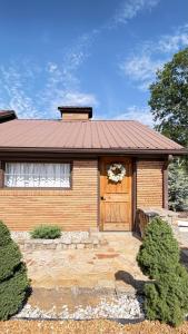 a brick house with a door with a wreath on it at cozy corner in Dalton