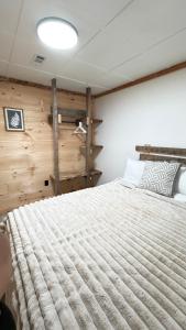 a bedroom with a large bed with a wooden wall at cozy corner in Dalton
