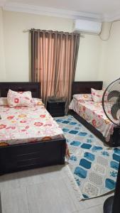 a bedroom with two beds and a tennis racket on the floor at Fahd palm beach chalet in Ain Sokhna +14 photos