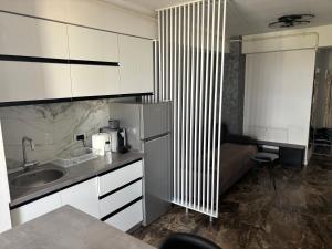 a kitchen with a refrigerator and a sink and a couch at Apartament bloc nou - self check in - free parking in Craiova +15 photos
