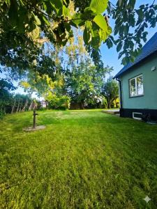 a yard with a house and green grass at The Green House Holiday Home in Tomelilla